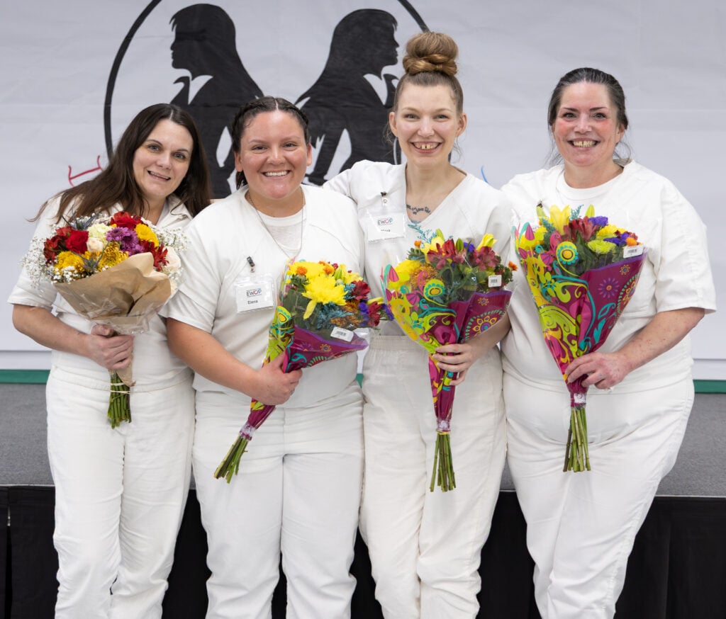 Four EWOP participants holding bouquets at the annual business plan competition