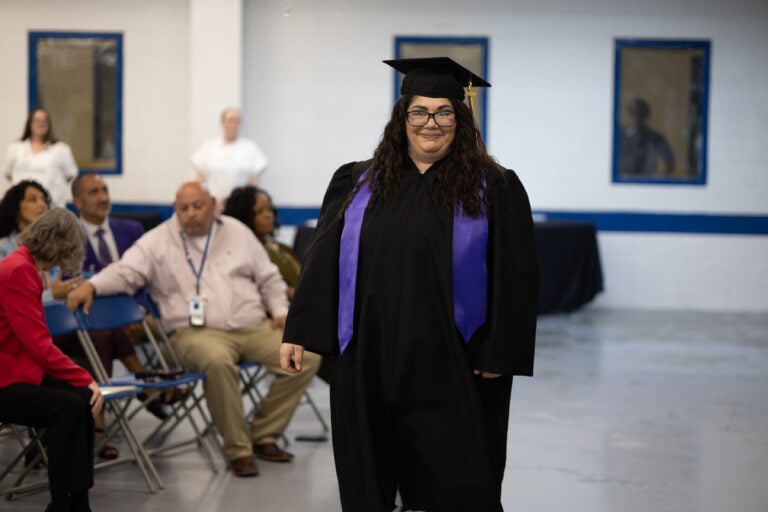 An EWOP graduate in cap and gown at her graduation ceremony